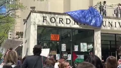 Large crowd outside Fordham University in NYC chant