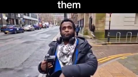 Somalia Migrant wearing a Palestinian scarf explains what he is doing in the UK.
