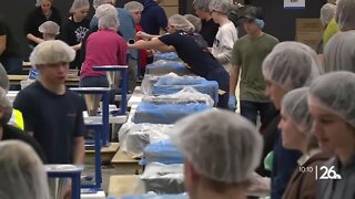 Volunteers team up to pack meals for children in need around the world