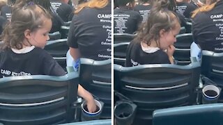 Little girl sticks her hand in random cup of soda at baseball game