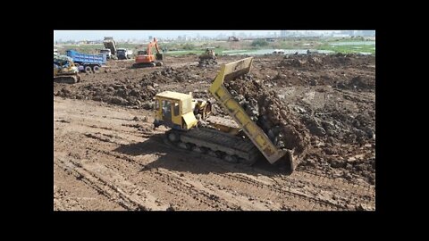 The skill of controlling a bulldozer Excavator and truck move the soil on the lake.