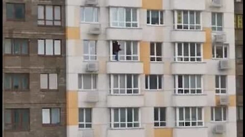 Un homme nettoie l'extérieur de ses fenêtres... au 18e étage