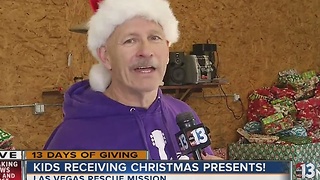 Volunteer talks about 13 Days of Giving at toy giveaway