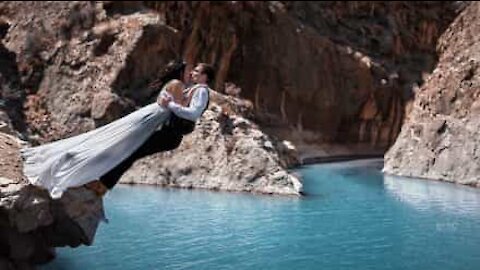 Par falder i vandet for at få det perfekte bryllupsbillede