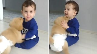 Baby adorably tries to escape sweet puppy kisses
