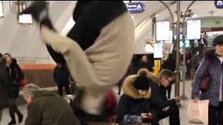 Guy in busy metro station does somersault out of nowhere