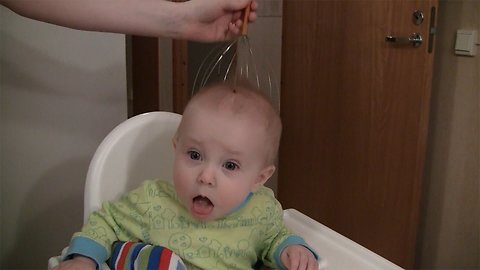 Cute baby reacting to head massager