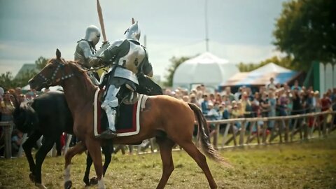 Knights having a battle on wooden swords on the field - people watching behind the fence - medieval