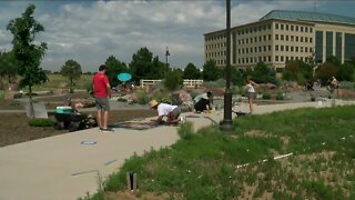 People stop by Reflection Garden Memorial to remember Aurora theater victims