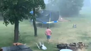 Homem enfrenta tempestade de verão para salvar cama elástica