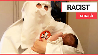 Dad pictured holding his baby dressed in Ku Klux Klan robes