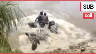Brave farmers drive their tractor underwater "like a submarine" to cross a deep river between farms