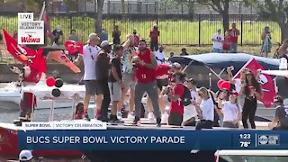 Mike Evans throwing football off boat along parade route