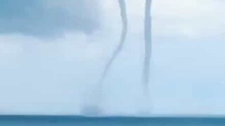 Rare moment two waterspouts form at sea