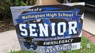 Volunteers place signs in yards of Wellington High School seniors