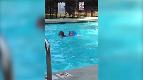 "A Boy Jumps into A Pool Through A Small Inner Tube"