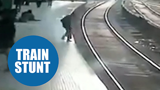 Moment a man miraculously walked away unharmed - despite lying under a TRAIN