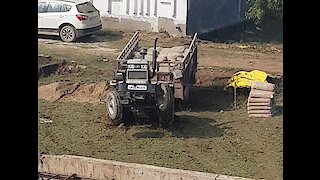 Tractor doing stunts after getting stuck in the mud.
