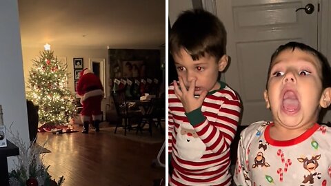 Excited Kids "Caught" Santa Putting Presents Under The Christmas Tree