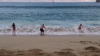 A Large Wave Knocks Down A Family On The Beach