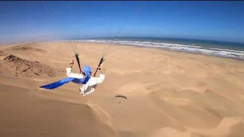 Paraglider flies over stunning Moroccan beach
