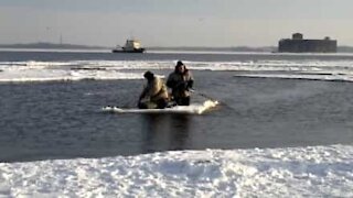 Fishermen on ice sheet row their way back to shore