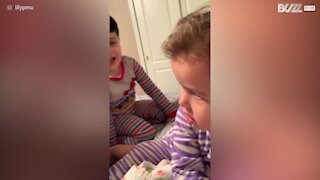 Petite fille pousse son frère du lit