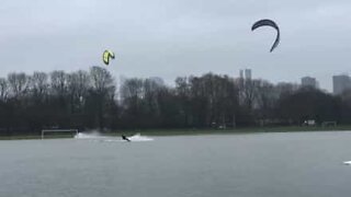 Kitesurfers enjoy themselves on a flooded soccer pitch