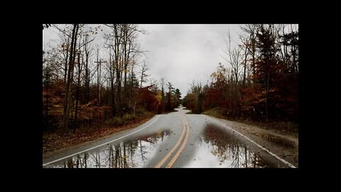 Autumn rainfall on a lonely curvy tarmac road