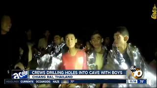 Crews drilling holes into cave with boys