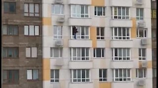 Man cleans outside window of his 18-storey high apartment