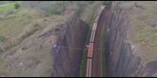 Atleta de Slackline atravessa por cima de linha ferroviária