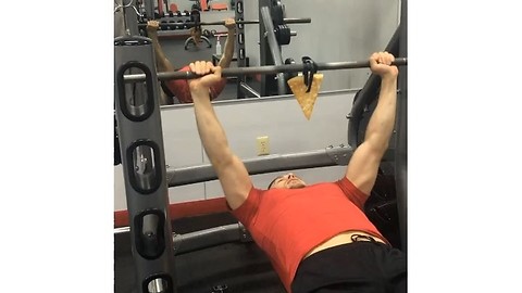 Boy eating pizza while exercising in the gym
