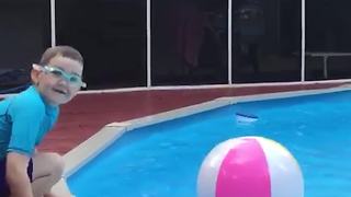 Boy Fails In Jumping On Top Of A Ball In A Pool