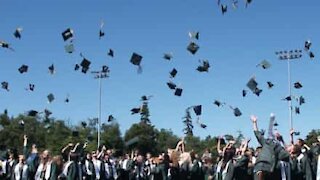 Jovem tropeça de sapatos de saltos altos em plena graduação