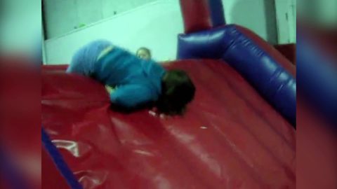 "Bouncy Castle FAIL: Woman Struggles To Get On Top Of Slide"