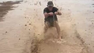 Man has fun skiing through mud barefoot