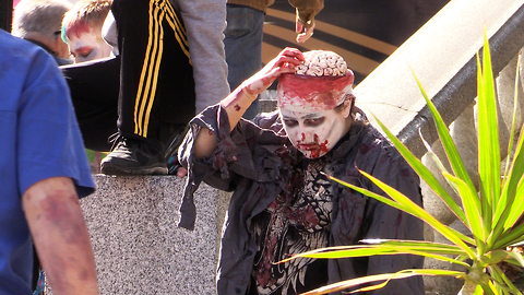 Zombie picks brain and eats it at Halifax Zombie Walk