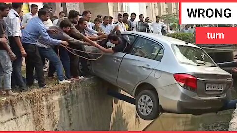 Watch moment man is rescued from car after reversing into a ditch and getting stuck on a drain pipe