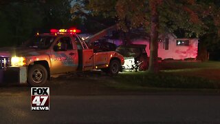 Man hospitalized after crash into parked truck, house