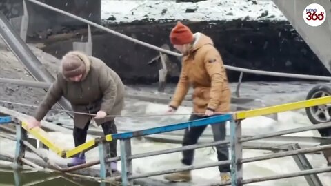 Ukrainians cross destroyed bridge near Kiev to evacuate