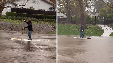 Resident paddleboards through flooded streets of Goleta, CA