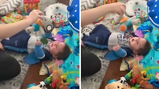Baby has uncontrollable giggles from playing with his mommy