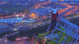 Aventureiro escala guindaste para passar mensagem inspiradora