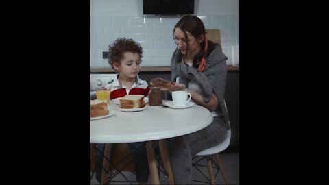 Happy Toddler child- having breakfast with women