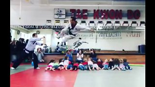 Tae Kwon Do master leaps over 16 children to break board