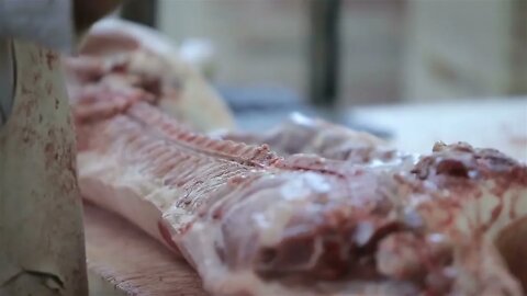 Butcher Cutting Pork Meat in Meat Factory. Fresh raw pork chops in meat factory. Meat processing in