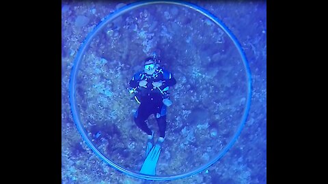 Dive master entertains clients with skillful with underwater bubble rings