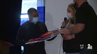 Ravens center Bradley Bozeman presents local volunteer with tickets to the Super Bowl