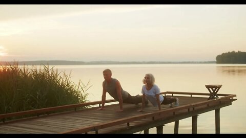couples yoga on a dock